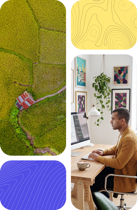 Developer working at a desktop alongside aerial imagery representing structured software delivery